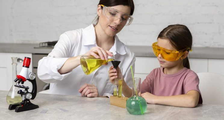 Una donna insegna ad una bambina a fare esperimenti scientifici