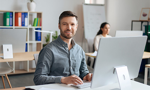 Primo piano di un professionista che lavora al computer in ufficio.